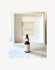 Forest Glow Elixir Bakuchiol Gesichtsöl von Skincare by Suni auf Nesselstoff mit Markenlogo im Hintergrund