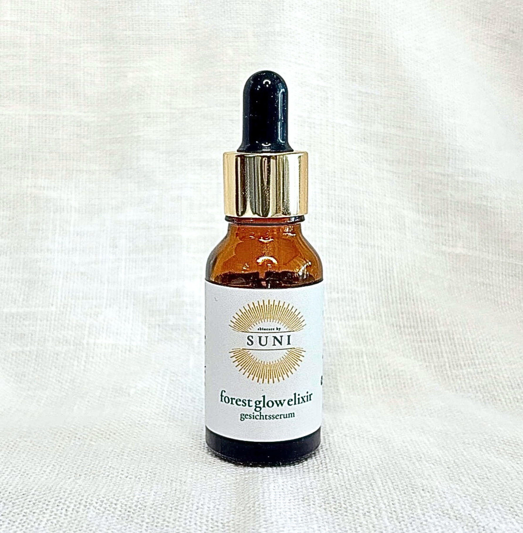 Detailaufnahme des Forest Glow Elixir Bakuchiol Gesichtsöl von Skincare by Suni auf weissem Leinenstoff