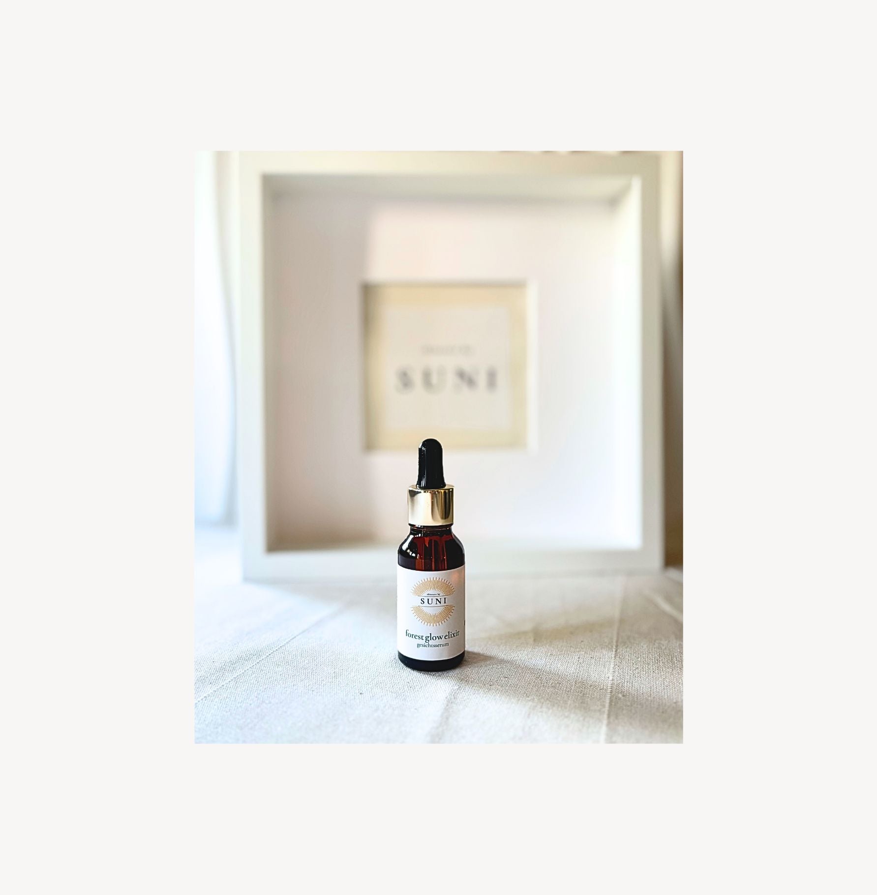 Forest Glow Elixir Bakuchiol Gesichtsöl von Skincare by Suni auf Nesselstoff mit Markenlogo im Hintergrund